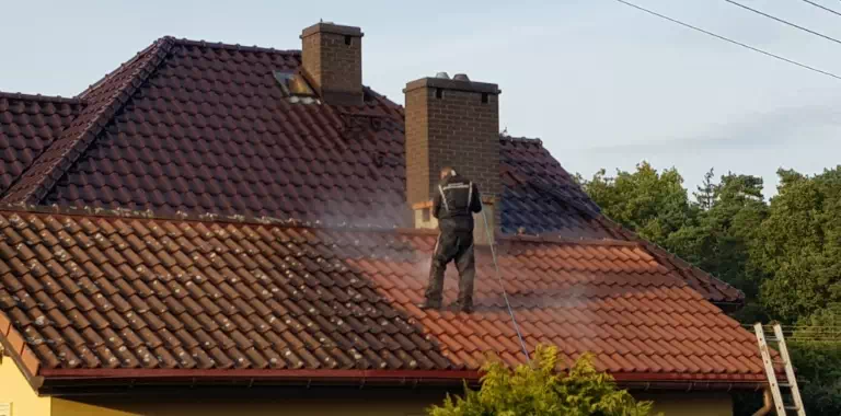 mężczyzna myjący dach